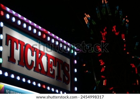 The ticket booth at a carnival midway at night.
