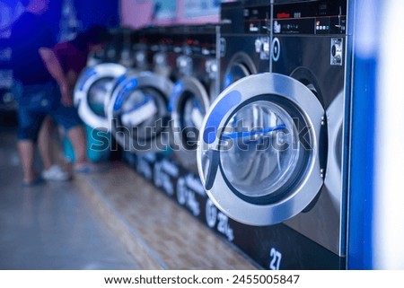 Qualified coin operated laundry machine in the public room to wash  cloths. Concept of a self service commercial laundry and drying machine in a public room. Coin operated Laundry Machines. Royalty-Free Stock Photo #2455005847