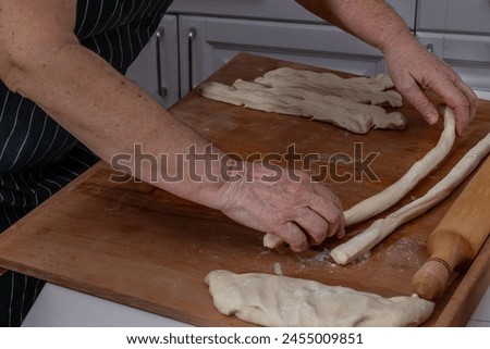 Woman kneading dough in kitchen.Women's hands knead the dough for dumplings