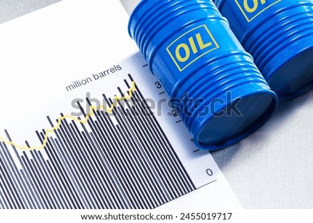 Changes in the fuel market. Crude oil barrels and chart of production crude oil. Royalty-Free Stock Photo #2455019717