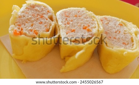 This picture is of finely chopped chicken meat, seasoned and rolled in egg, and served on a yellow plate