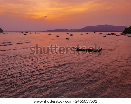 Nature sunset aerial view. Top view evening atmosphere when the sunset behind the mountains with a view of the sea reflecting the water in an orange color. Picture background feeling happy time, free