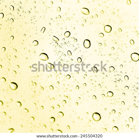 Drops of water on yellow glass