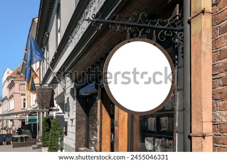 Mockup Of Blacksmith Style Antique Shop Signboard On The Street Of The Old Town. Blank Round Store Sign Hanging On The Wall