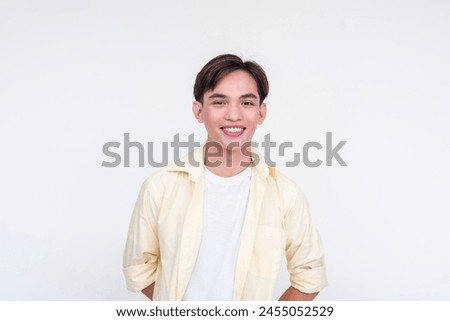 A handsome young asian man in an unbuttoned yellow polo and white shirt. Boy next door vibes. Isolated on a white background.