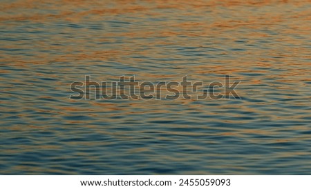 Golden Sea At Sunset. Reflection And Ripples On Sea Water Surface At Sunset. Slow motion.