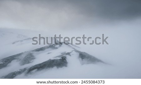 Blizzard Over Antarctica Mountains. Aerial Over South Pole. Harsh Wild Environment. Natural Polar Phenomena in Antarctic Midsummer. Winter Landscape In Grey White Tints. Royalty-Free Stock Photo #2455084373