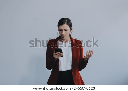 Upset young asian woman holding smartphone standing on isolated white background. She was very stressed and depressed.