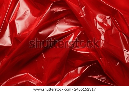 Processed collage of red plastic cellophane surface texture. Background for banner, backdrop or texture for 3D mapping
