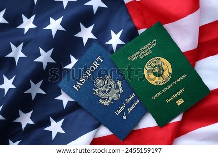 Passport of Nigeria with US Passport on United States of America folded flag close up