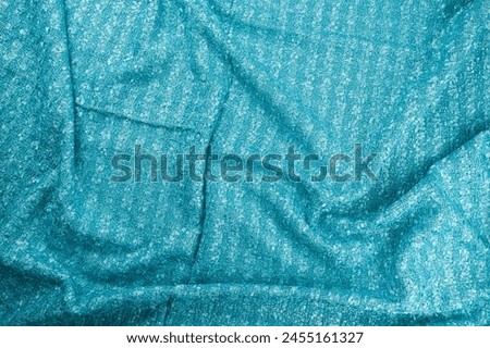 Texture of draped wool  light blue fabric with stripes, top view, textured background.
