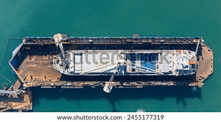 Dry dock with Cargo Ship maintenance or repair at floating dock in shipyard both deck crane loading during bring ship in to the dry dock. Royalty-Free Stock Photo #2455177319