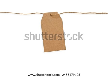 Blank kraft paper tag on a string isolated on white background with clipping path and copy space for text. Brown cardboard label with slim rope cord. Price tag, gift tag, sale tag, address label.