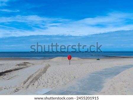 North Sea beach in the Netherlands in Julianadorp ann Zee. Pedestrian path, garbage can and tent in the picture
