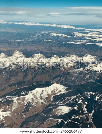 As winter approaches, A picture from airplane window a blanket of pristine white snow covering the landscape below.