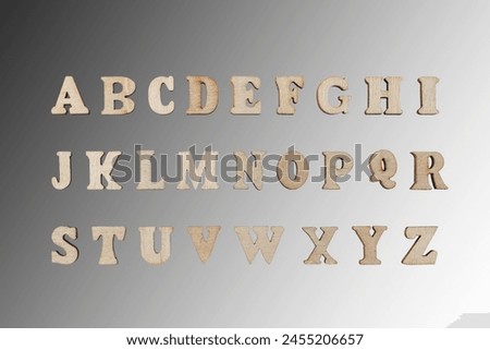 wooden letters of the English alphabet on a gray gradient background close-up