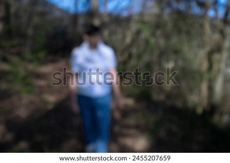 Bokeh out of focus picture of a man walking in the forest