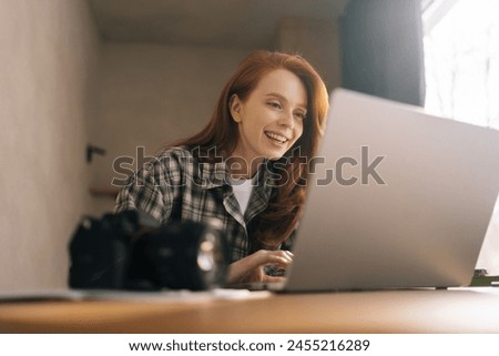 Low-angle view of female editor working in home photo studio, retouching bad shot on laptop computer. Photographer drawing graphic with high quality image editing, enjoying making design of picture.