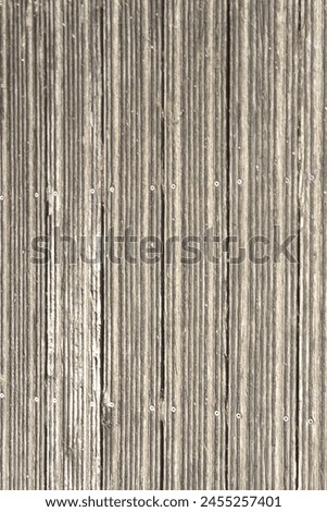 Heavilly weathered granular decking producing a linear pattern indispersed with a pattern of screw heads. Royalty-Free Stock Photo #2455257401