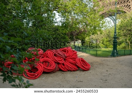 Corrugated red pipe near the Eiffel Tower on the Champ de Mars, used to protect trees during construction for the Paris Olympics Royalty-Free Stock Photo #2455260533