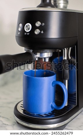 A close up picture of fresh hot coffee running out of the portafilter of a coffee machine. Coffee extraction from the coffee machine. Espresso pouring from machine.