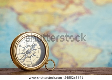  Old brass compass against world map background