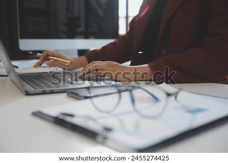 
Cropped image of professional businesswoman working at her office via laptop, young female manager using portable computer device while sitting at modern loft, flare light, work process concept