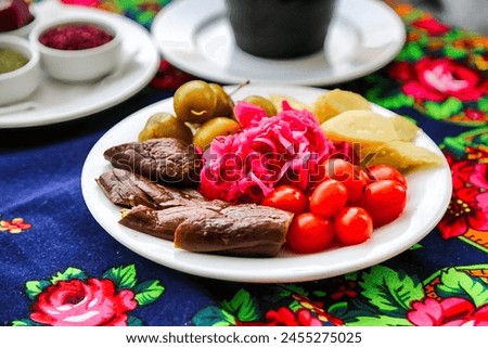 A delectable white plate showcasing a delectable arrangement of meat and vegetables. Royalty-Free Stock Photo #2455275025