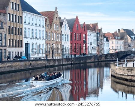 Tourist boat on canal in Bruges in a beautiful summer day, Belgium. High quality photo