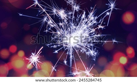 A bright white sparkler with a multi colored background