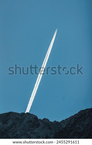 A sleek airplane soars gracefully against the vast blue sky, high above the earth, showcasing freedom and adventure