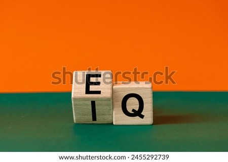 EI or EQ icon. A wooden block with a word showing both the symbol of emotional intelligence and emotional quotient. Beautiful green and orange background, copy space. Psychological and EI or EQ