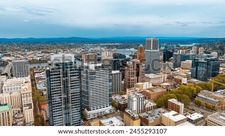 Downtown of Portland, Oregon, the USA with high-rise architecture. Twilight view of the city with mountain silhouettes at backdrop.