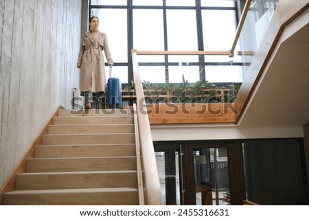 Beautiful businesswoman on stairs in modern hotel.