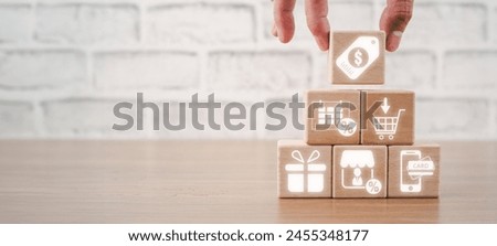 Black friday concept, Hand holding wooden block on desk with black friday icon on virtual screen.