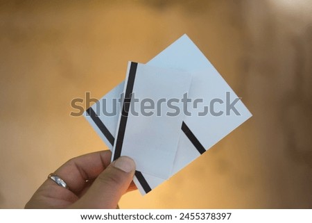 Cropped image of hand showing three paper ticket