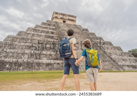 Father and son tourists observing the old pyramid and temple of the castle of the Mayan architecture known as Chichen Itza these are the ruins of this ancient pre-columbian civilization and part of Royalty-Free Stock Photo #2455383689
