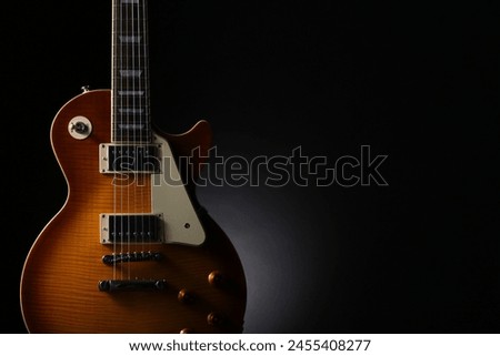 Silhouette of an electric guitar placed on a black background