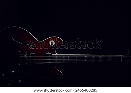 Silhouette of an electric guitar placed on a black background