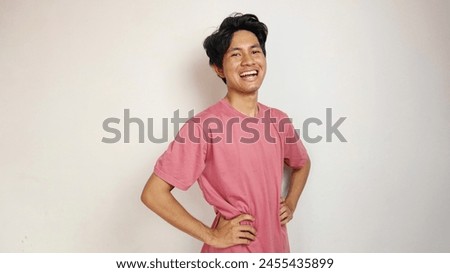 Handsome young Asian man is happy, cheerful and enthusiastic posing coolly with an isolated white background. wearing a red shirt Royalty-Free Stock Photo #2455435899
