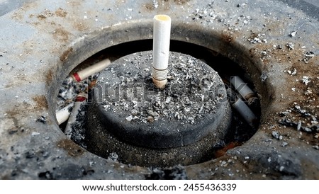 Picture of cigarette butts in a dirty ashtray as a symbol of unhealthy life and habits