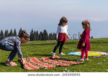 three sisters are having fun on a green lawn preparing to have a picnic