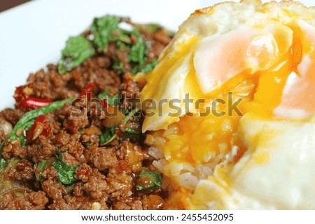 Closeup of Fried Egg Topped on Thai Style Stirred-fried Minced Beef and Holy Basil with Rice Called Kao Pad Kaprao Neua