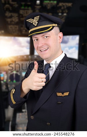 joyful young pilot with thumb up in cockpit