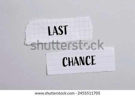 Last chance words written on ripped white paper pieces with gray background. Conceptual last chance symbol. Copy space.