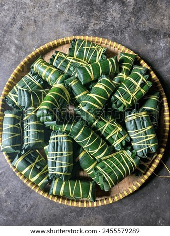 Buras in a tampah. Burasa is one of the specialties of the Bugis and Makassar communities in South Sulawesi. It is also known as lapat, lontong or buras.  Royalty-Free Stock Photo #2455579289