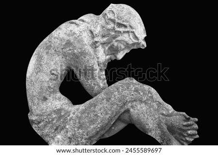Ancient statue of Jesus Christ against black background. Horizontal black and white image.