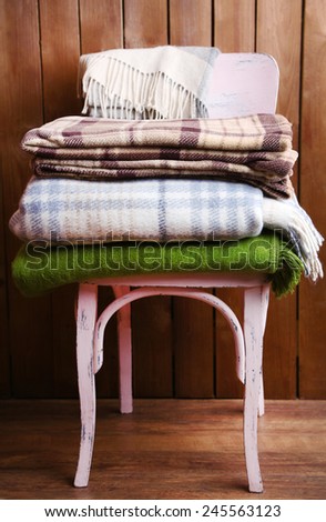 warm plaids on chair on rustic wooden background