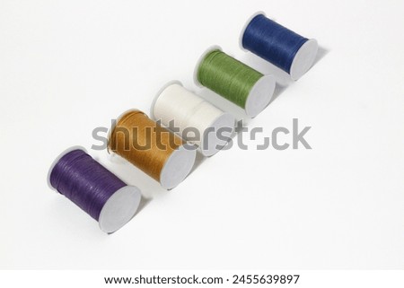 Spool of sewing thread, isolated on white background. Colored yarns used by factories in the clothing industry. Threads wound on the spool. Colored reels