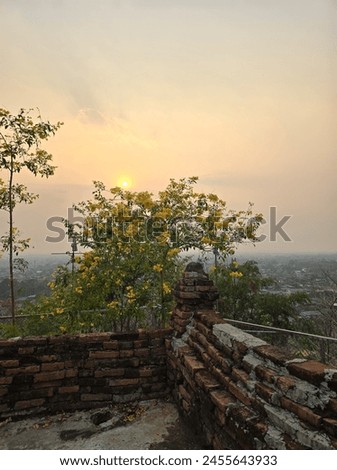 Picture of the sun about to set on the top of a mountain at a temple in the northern region.